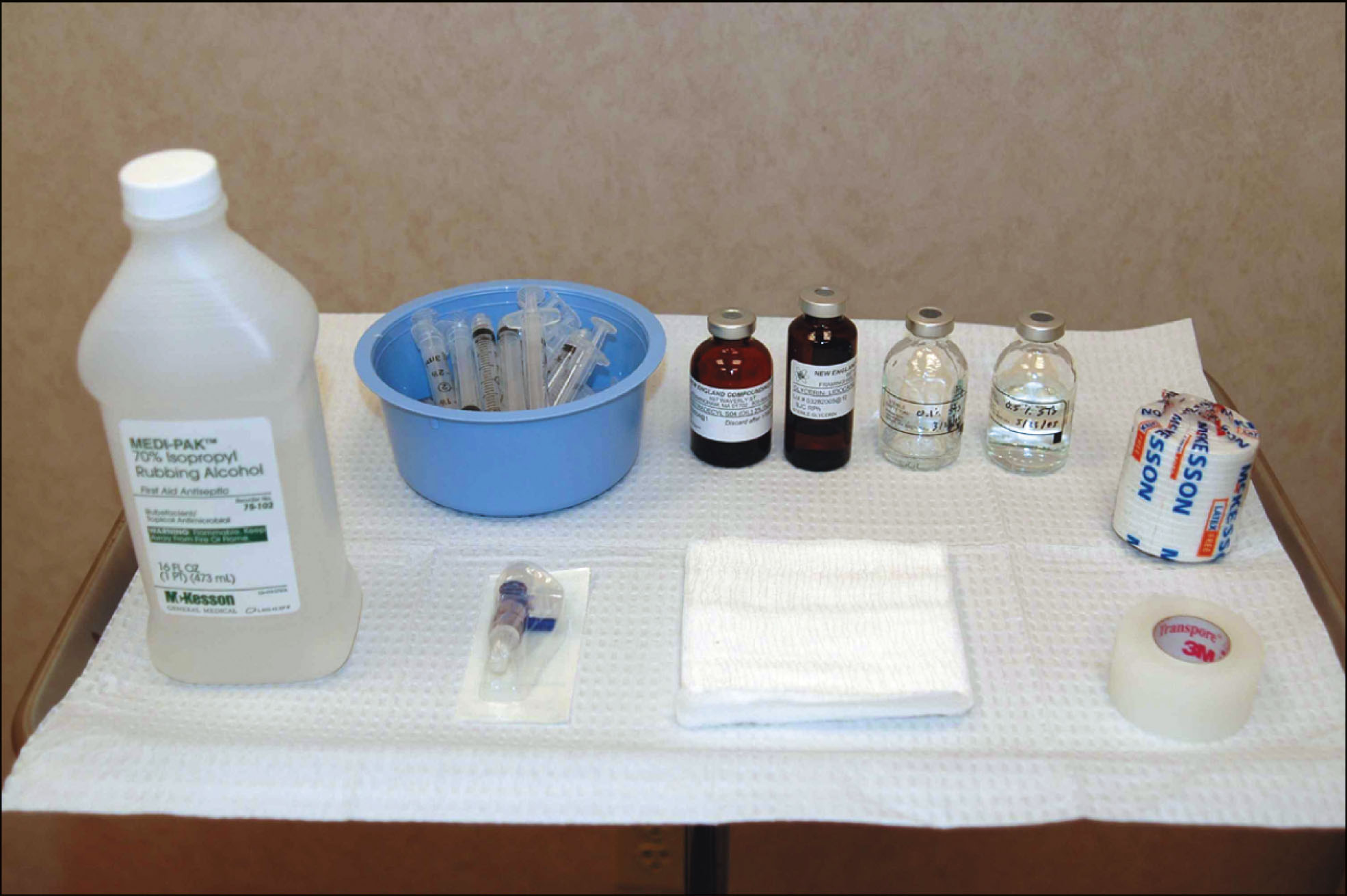 A photo features a sclerotherapy tray with syringes, sclerosant bottles, gauze, tape, and other injection supplies arranged on a surface.