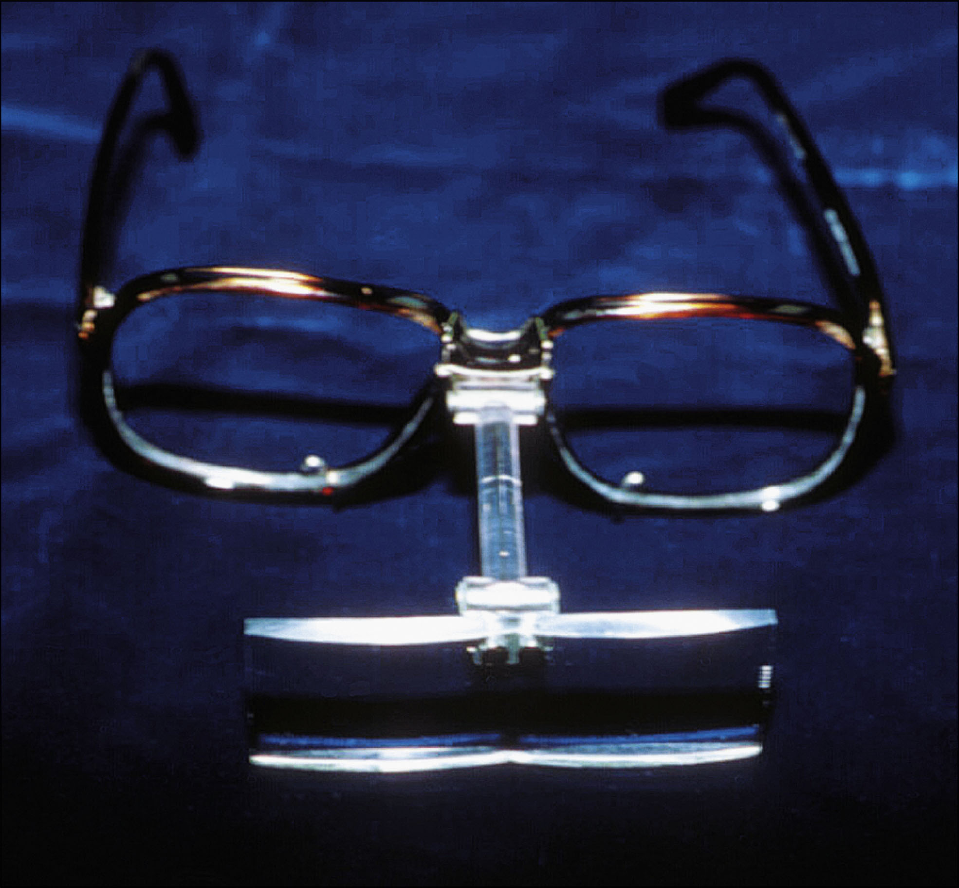 A photo features a pair of magnifying glasses with an attached optical aid device resting below the lenses.