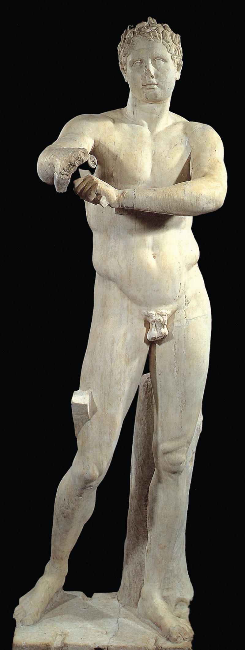 A statue of a male figure with a muscular build, depicted in a dynamic pose. The figure appears to be holding or adjusting an object, set against a black background.